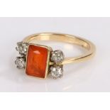 18 carat gold ring, set with an orange stone and flanked by diamonds, ring size N