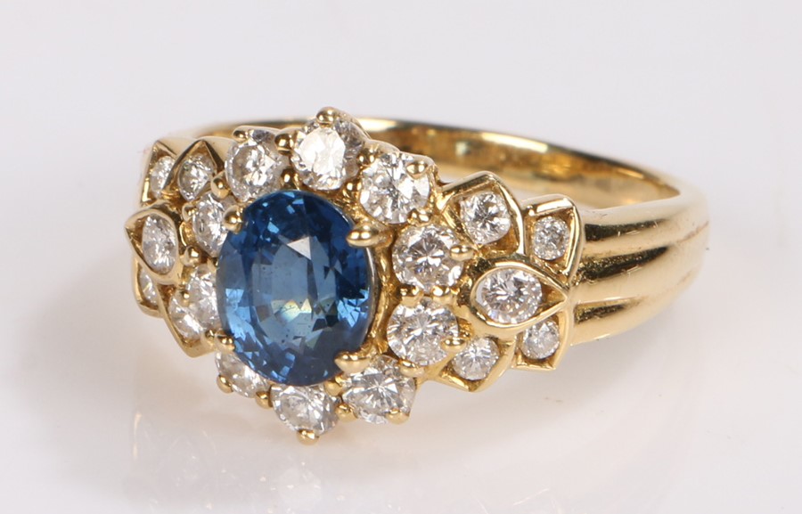 18 carat gold sapphire and diamond set ring, the central oval sapphire and a round cut diamond