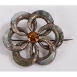 Silver and agate brooch, with a central orange stone and swirl surround, 54mm diameter