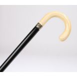 Victorian ivory cane, with a smooth arched ivory handle above a black ebonised cane, 91cm long