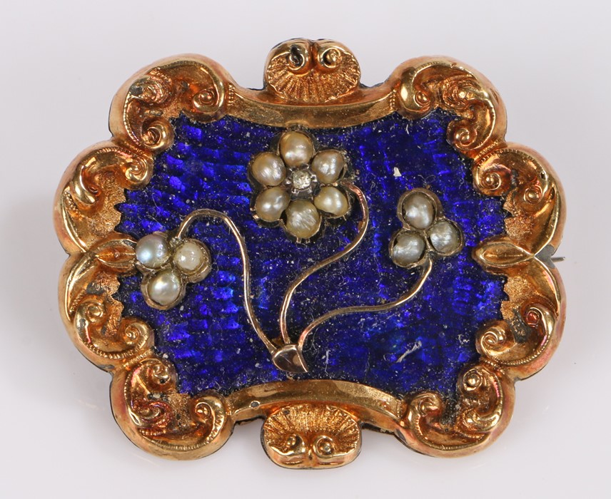 19th Century mourning brooch, with pearl set flowers on an enamel back and scroll frame, locket to