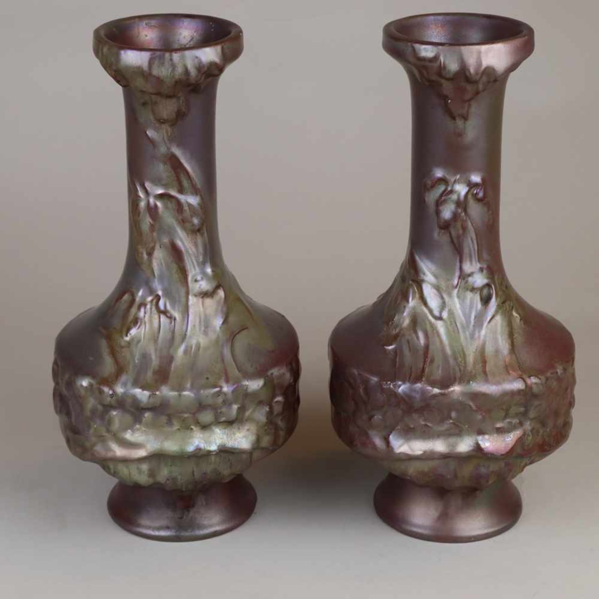 Paar Jugendstil-Vasen - Keramik, violett glasiert, irisiert, floraler Reliefdekor, an der Bodenseite