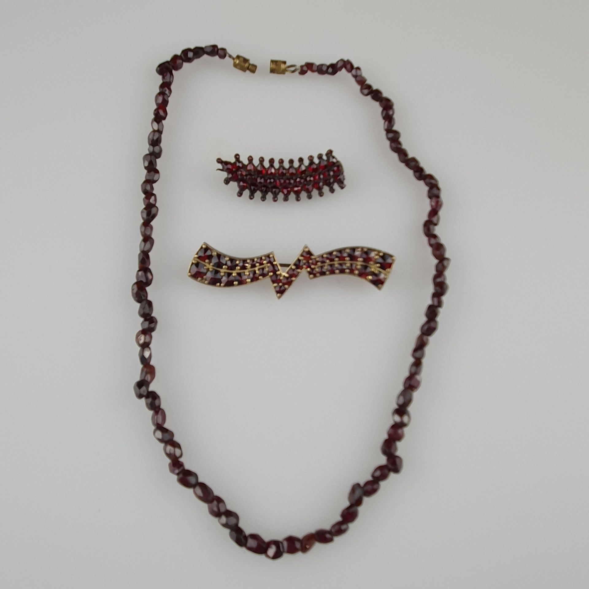 Granatschmuck-Konvolut - dreiteilig: 2x Broschen, L.ca.3,5 und 5,5cm, 1x Halskette mit