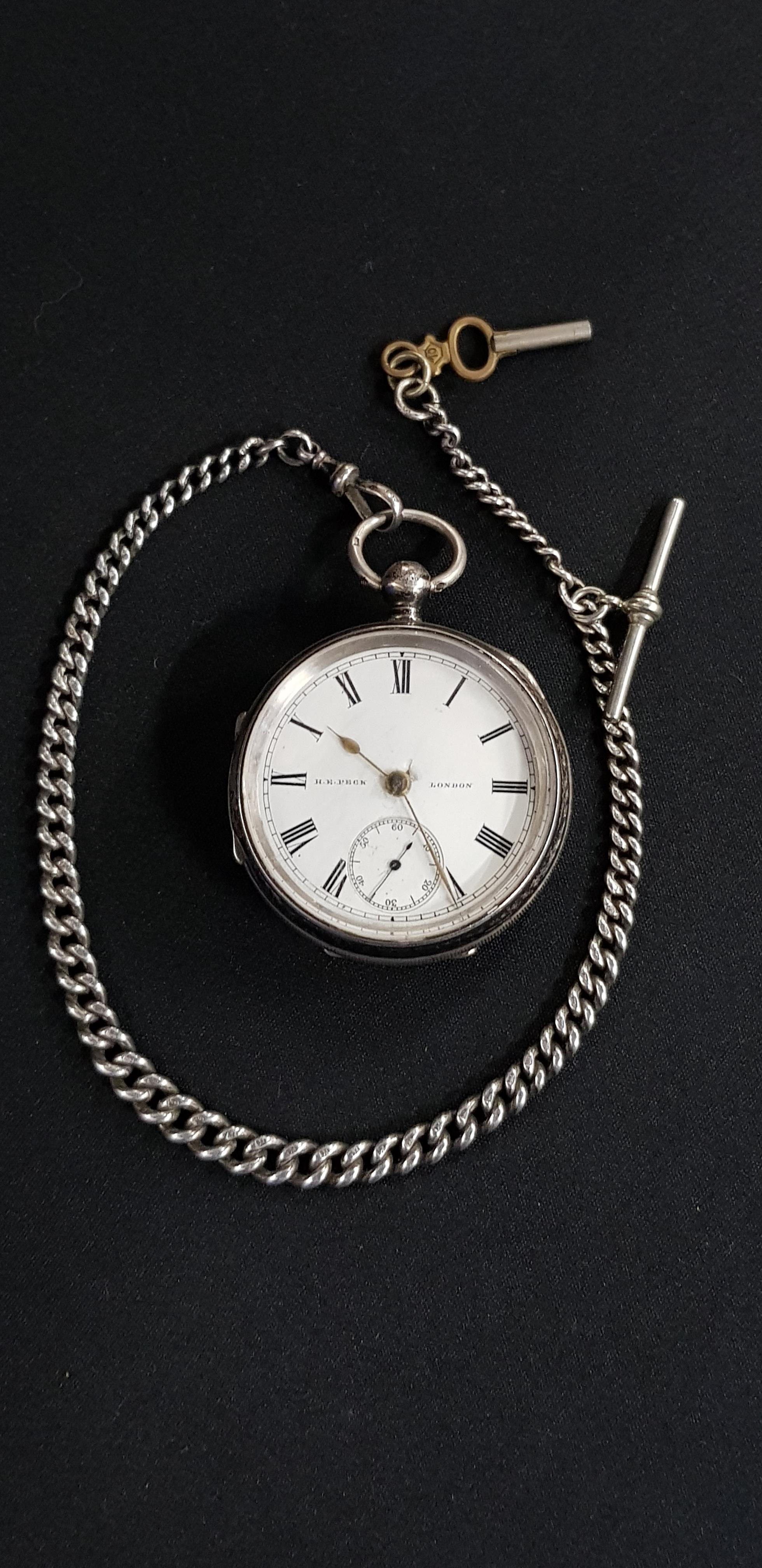 ANTIQUE SILVER POCKET WATCH ON ANTIQUE SILVER WATCH CHAIN WITH KEY