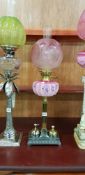 ANTIQUE PAINTED OIL LAMP WITH RUBY SHADE AND DOUBLE COUNTER BELL