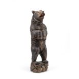 A late 19th/early 20th century Black Forest carved and stained lindenwood model of a standing bear