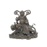 A late 19th/early 20th century Asian bronze model of a deity seated on a tiger, possibly showing ...