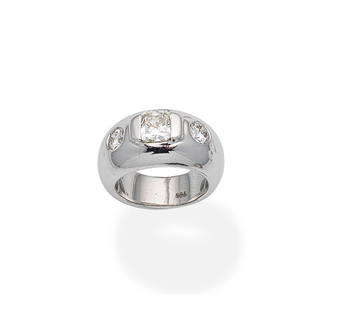 A diamond three-stone ringOf bombé design, centrally set with a radiant ...