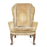 A late 19th/early 20th century walnut wingback armchairin the George II style