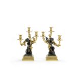 A pair of mid-19th century gilt and patinated bronze three-light figural candelabre in the Louis ...
