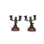 A pair of late 19th century French patinated bronze twin branch dwarf figural candelabra in the ...