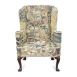 A 19th century mahogany wingback armchair upholstered with early 18th century tapestry fragments