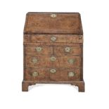 A Queen Anne walnut and featherbanded bureau with an unusual concealed drawer