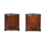 A pair of early 19th century German figured mahogany bowfronted marble top corner cabinets (2)