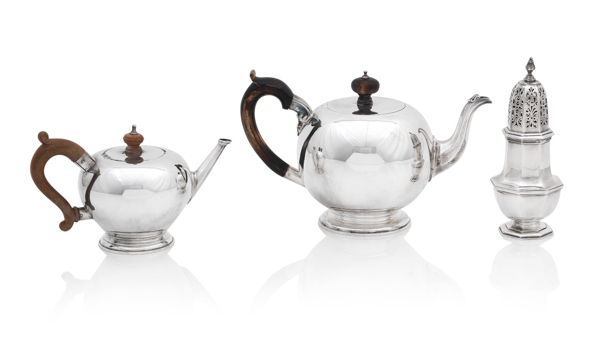 Two bullet style modern silver teapots, and a sugar caster the largest by Garrard & Co, London 2...