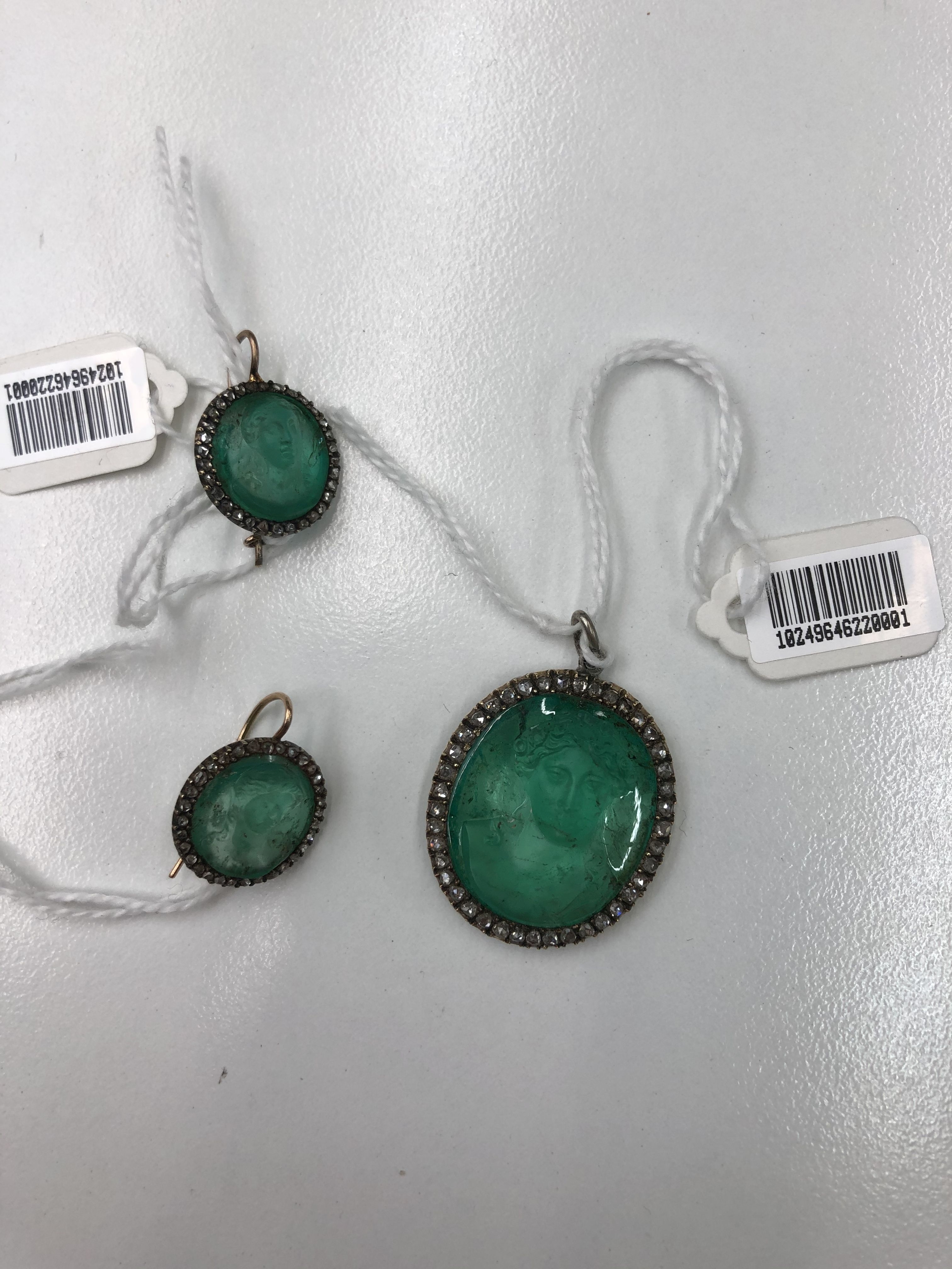 An emerald cameo and diamond pendant and pair of earrings,