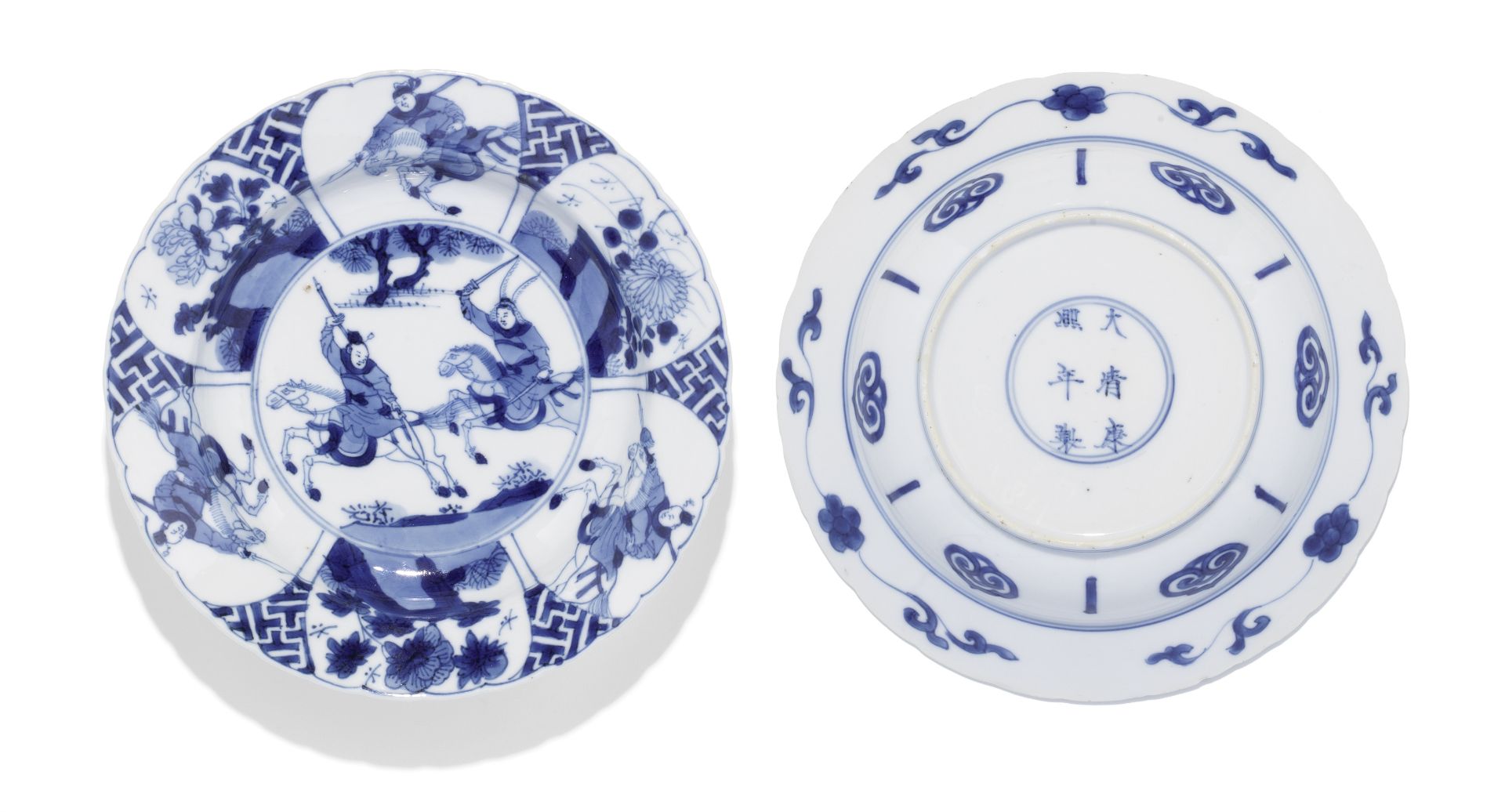 A pair of blue and white 'hunting' foliate-rimmed dishes Kangxi six-character marks and of the pe...