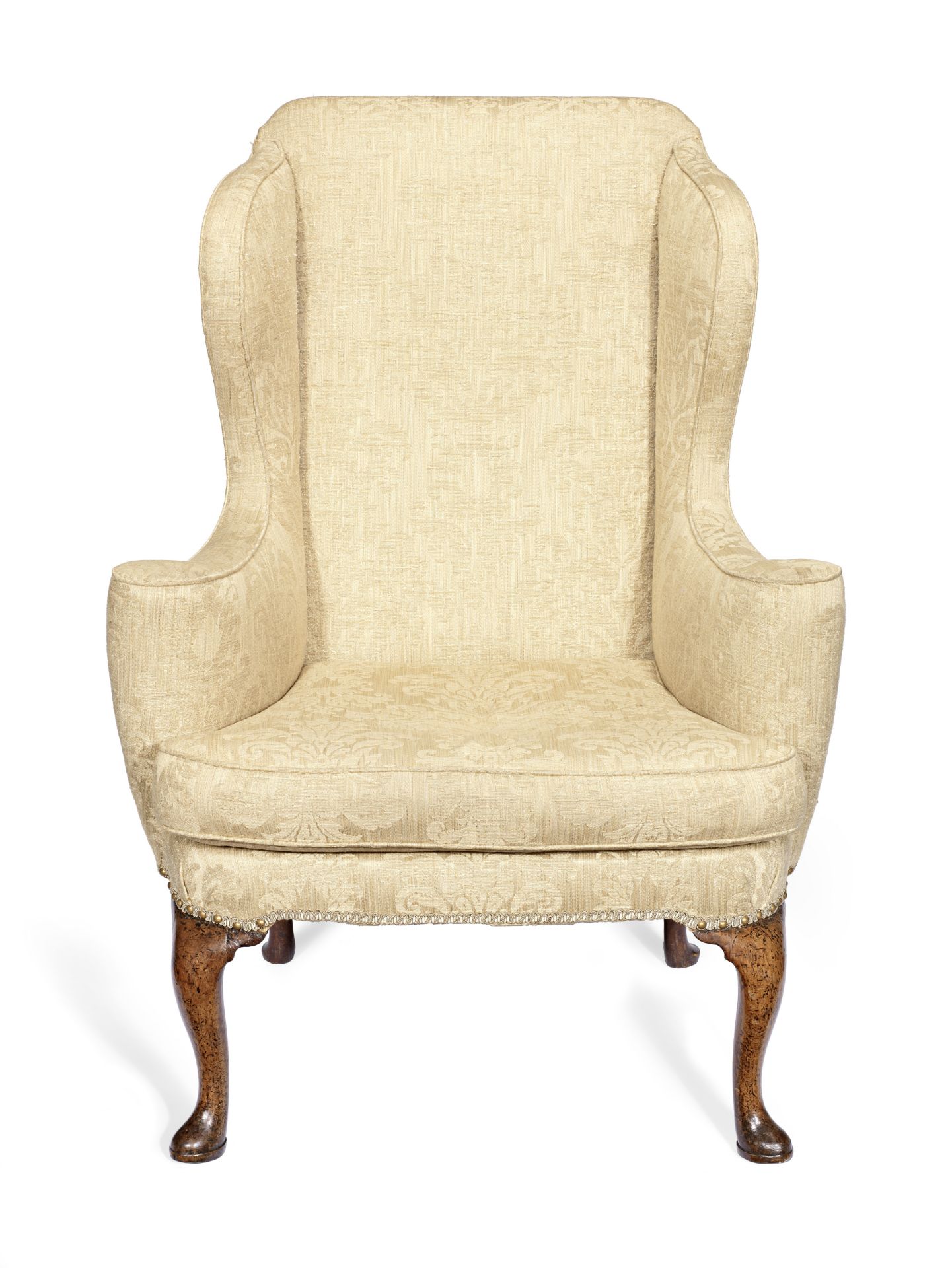 A walnut wingback armchair in the George II style