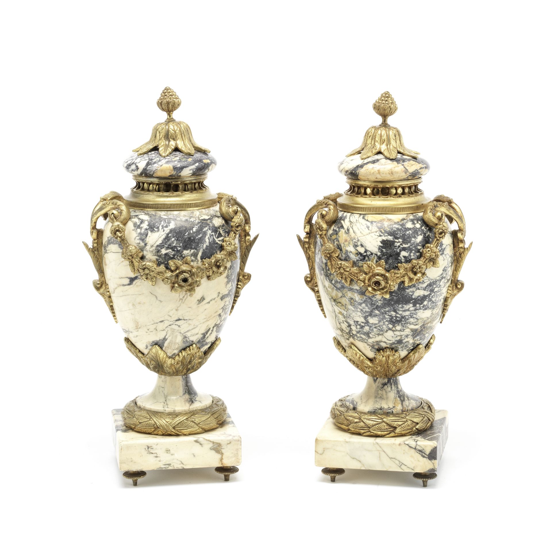 A pair of gilt bronze mounted beige veined marble garniture urns in the Louis XVI style, probabl...