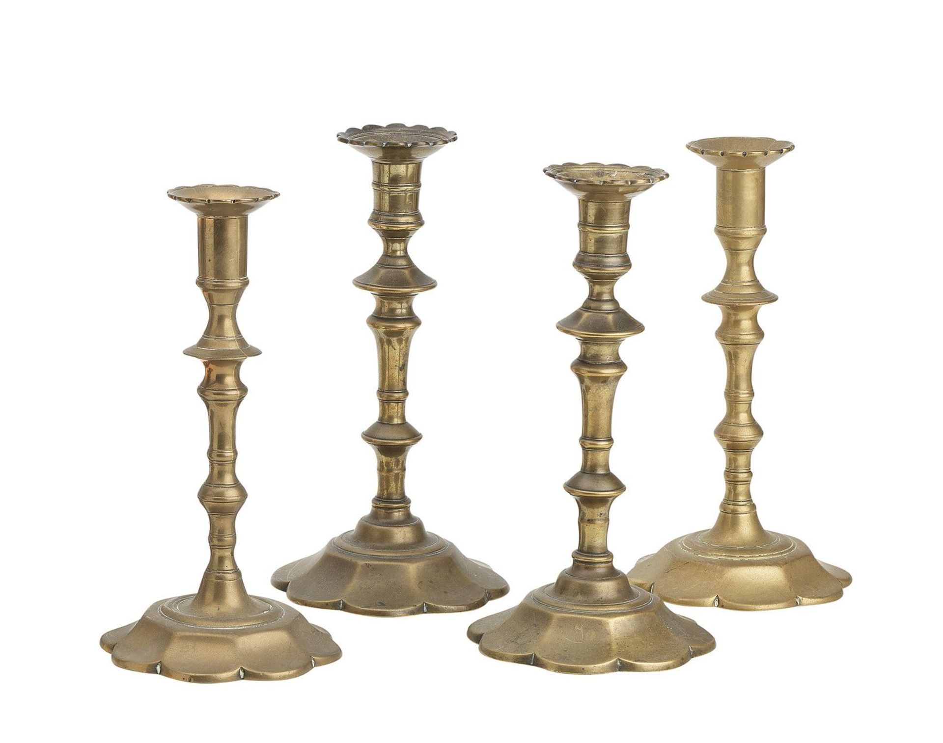 Two similar pairs of brass petal base candlesticks circa 1760