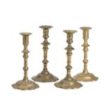 Two similar pairs of brass petal base candlesticks circa 1760