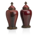 Pair of giltmetal mounted sang de boeuf pottery vases & covers; French 20th century