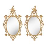 A pair of Chippendale style carved giltwood oval mirrors, early 20th century