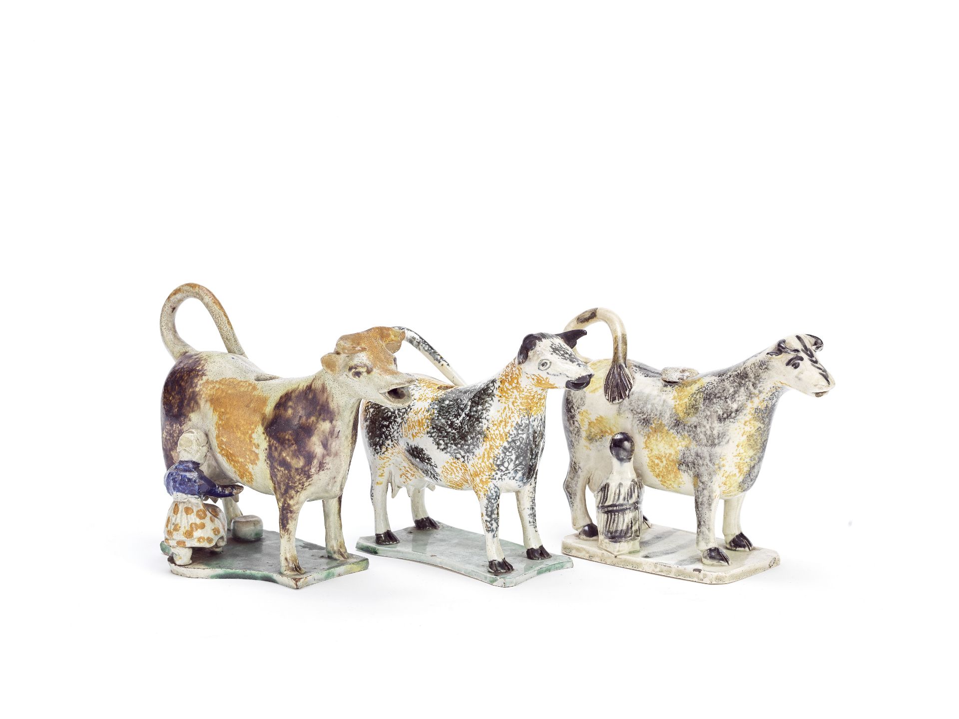 Three Staffordshire or Yorkshire cow creamers and a cover, circa 1810-20