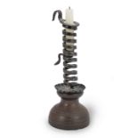 A 19th century wrought iron spiral candlestick on a painted beech base, French