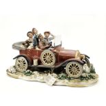 A large Veteran motoring porcelain figural group by Capodimonte, Italian,