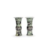 An associated mirrored pair of moulded black-ground famille verte beaker vases, gu Chenghua six-c...