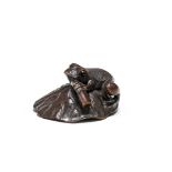 A wood netsuke of a toad on a lotus leaf Early/mid-19th century