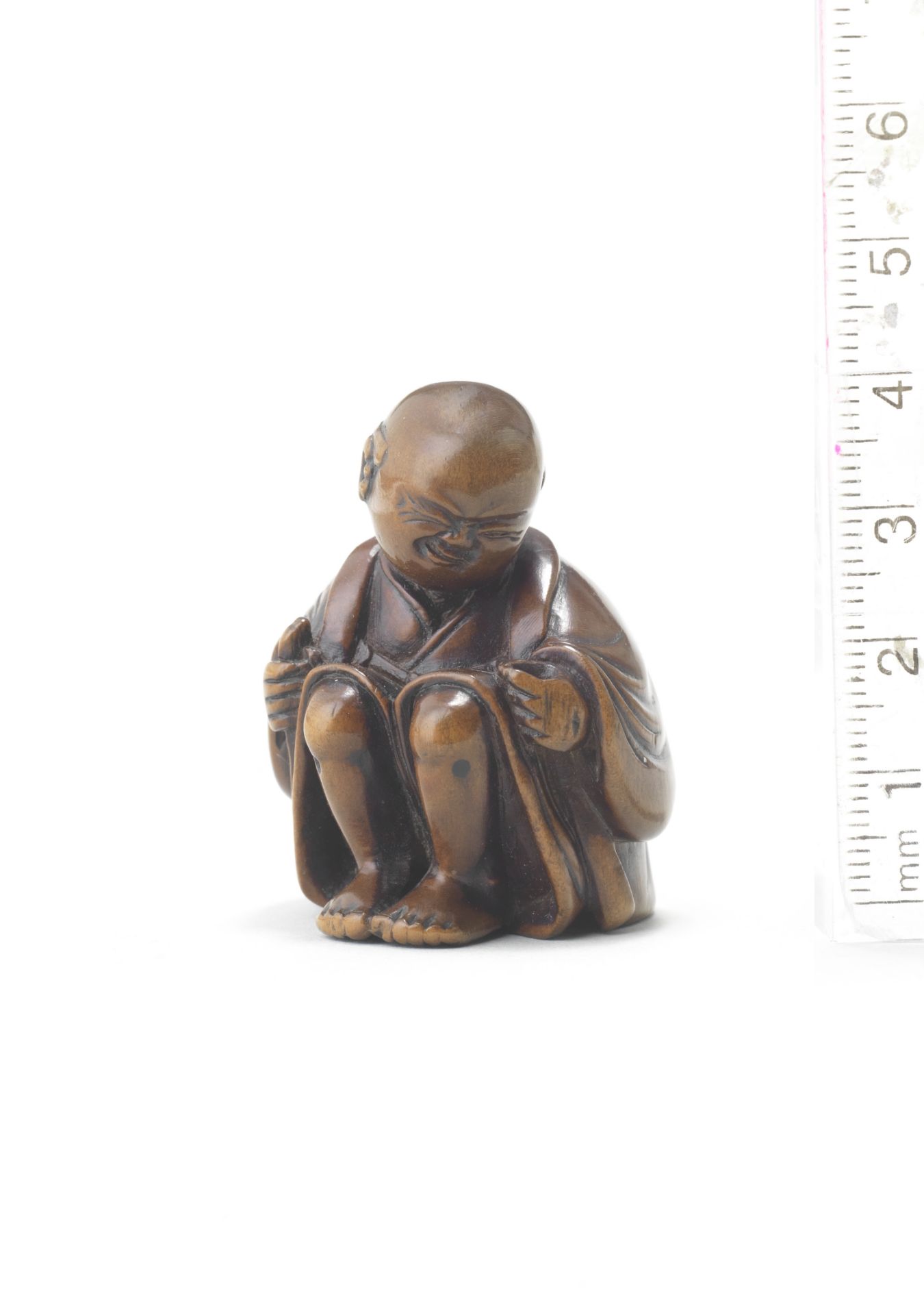 A wood netsuke of a man applying moxa Attributed to Miwa, late 18th/early 19th century