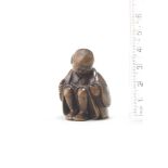 A wood netsuke of a man applying moxa Attributed to Miwa, late 18th/early 19th century