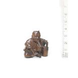 An okimono-style wood netsuke of oni no nenbutsu By Kyokumin, mid-late 19th century