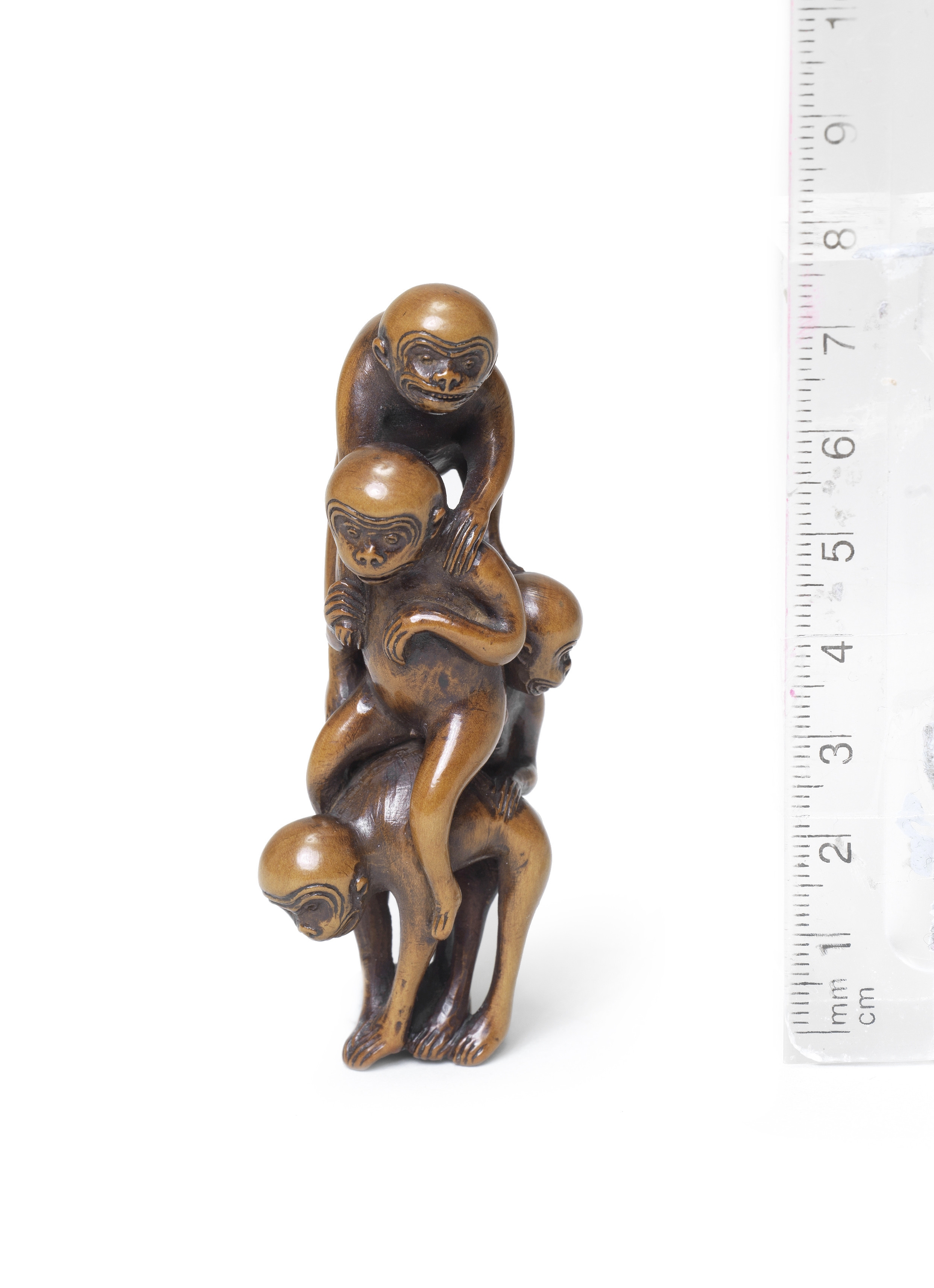 A wood netsuke of a pyramid of monkeys 18th century