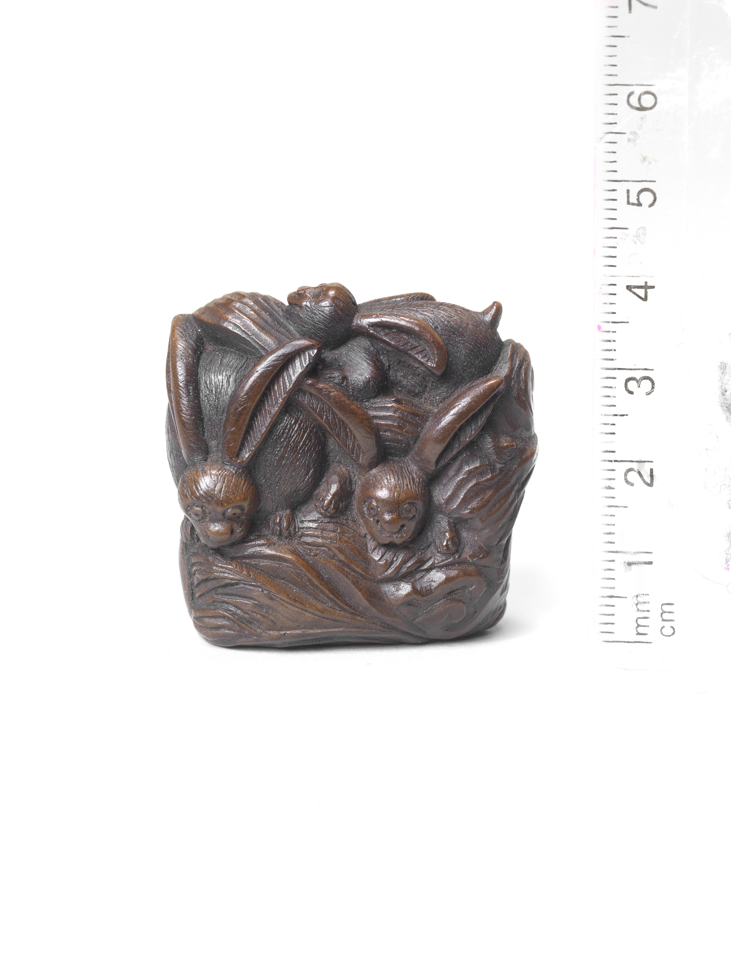 A wood netsuke of rabbits on a rock Early 19th century