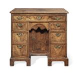 A George I walnut crossbanded and feather banded kneehole desk