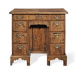 A George II walnut, crossbanded and feather banded kneehole desk