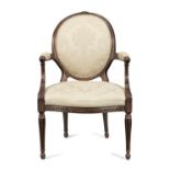 A George III walnut armchair in the French taste In the manner of Thomas Chippendale