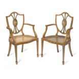 A pair of Edwardian stainwood and polychrome decorated armchairs In the George III style