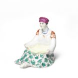 A Soviet Russian porcelain figurine of a seated peasant womanafter the model by Natalia Danko (18...