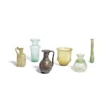 Four Roman glass vessels together with an aubergine glass bottle and a green glass bottle, 6