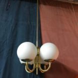 An Art Deco ceiling light designed with brass body and 4 white globe shades. One shade damaged