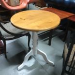 A farmhouse pine small round table supported on tri legs