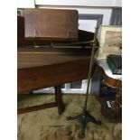 A Victorian rise and fall music stand, has an ornate cast iron base, brass gilt body and wooden book