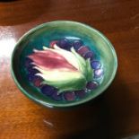 A William Moorcroft leaf and berry design bowl. Has original sticker to the base. Measures 4x11.5cm