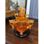 A Large Amber style three foot censor pot with lid. Designed with carved dragon handles with