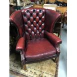 An oxblood red Chesterfield gullwing armchair