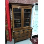 Antique two over two chest of drawers with a bookcase top with fitted shelving and glass front